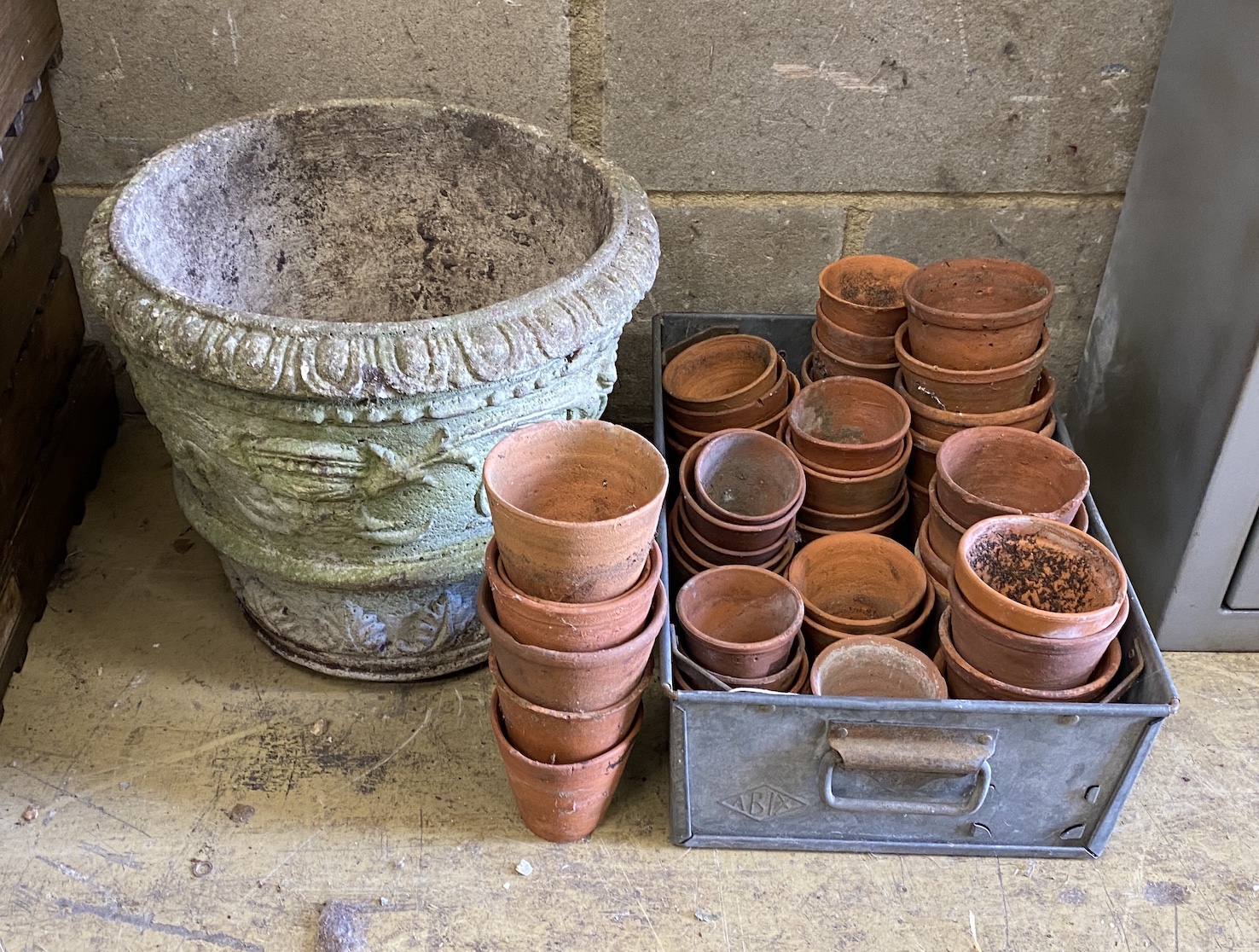 Approximately 45 assorted small terracotta pots and a circular reconstituted stone planter, diameter 37cm, height 32cm
